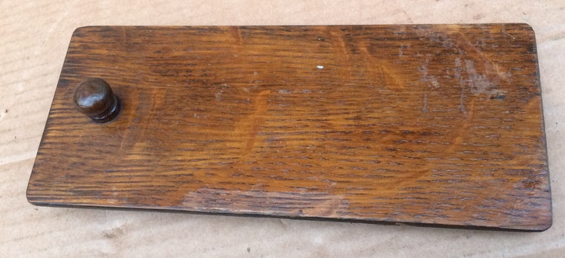 Pu&ograve; includere: Una maniglia per cassetto in legno con finitura marrone scuro e un pomo rotondo. La maniglia ha una forma rettangolare ed &egrave; realizzata in legno massello.