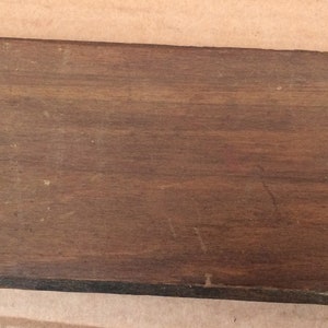 Pu&ograve; includere: Una scatola di legno con una chiusura in metallo. La scatola &egrave; marrone e ha una superficie liscia.