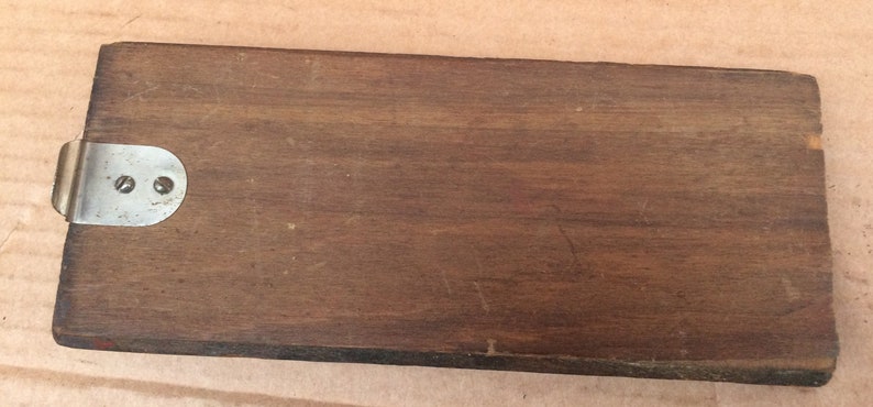 Pu&ograve; includere: Una scatola di legno con una chiusura in metallo. La scatola &egrave; marrone e ha una superficie liscia.