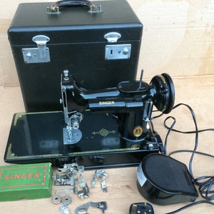 Máquina de costura Singer Featherweight 221K com acessórios.