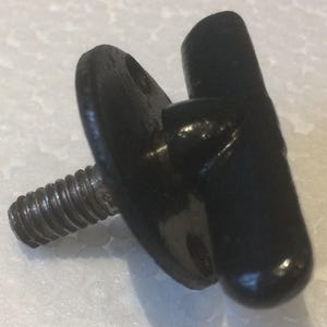 May include: A black, metal thumb screw with a threaded shaft and a rounded, wing-shaped head. The head has a hole for tightening. The screw is designed for manual adjustment and fastening.
