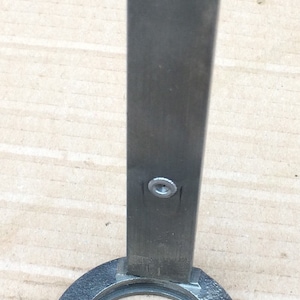 Może przedstawiać: Srebrne metalowe narzędzie z okrągłym pierścieniem i prostym uchwytem. Narzędzie jest oznaczone "SIMPLY TOOLS".