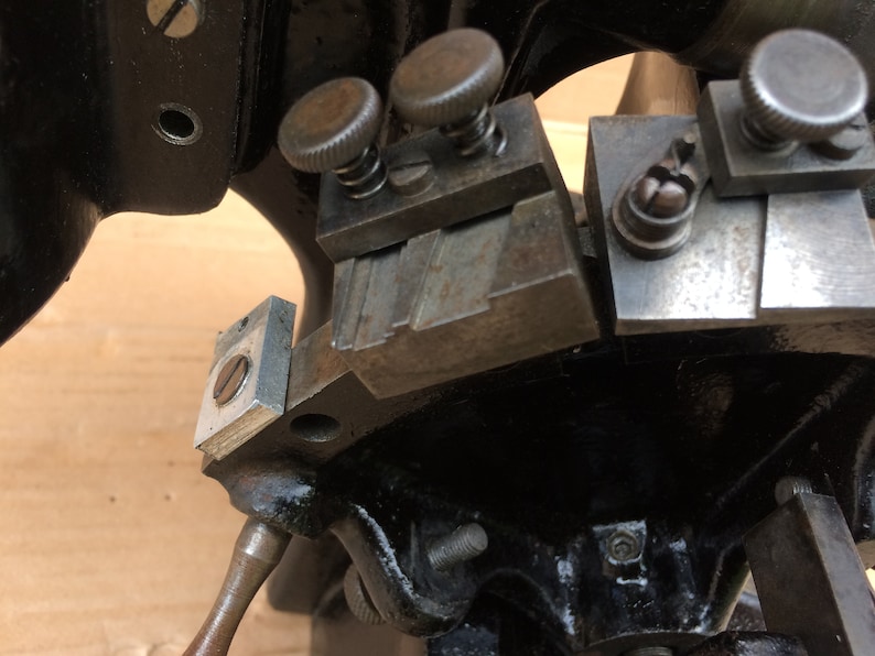 Puede incluir: Primer plano de una herramienta de metal con m&uacute;ltiples partes ajustables. La herramienta tiene un acabado plateado y est&aacute; hecha de metal. La herramienta tiene una serie de ranuras ajustables y una perilla para apretar.