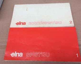 May include: Two white and red instruction manuals for an Elna sewing machine. The top manual has the text "elna ECZZ SPISTSU 2" and the bottom manual has the text "elna SPISTSU 1".