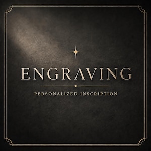 May include: A dark charcoal textured background featuring the gold-colored text ENGRAVING in a serif font, with the words PERSONALIZED INSCRIPTION below it. A four-pointed star icon sits above the text, and a thin gold border frames the entire image.