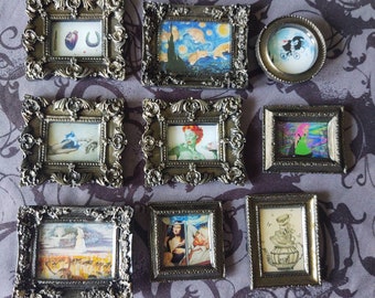 May include: A collection of small, ornate silver-colored picture frames, each containing a unique miniature artwork. The artworks feature diverse themes, including famous paintings, whimsical illustrations, and surreal imagery. The frames are arranged on a patterned purple surface.