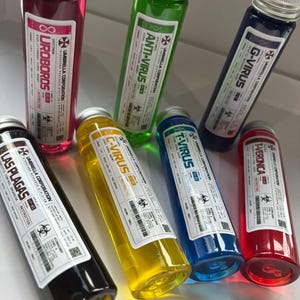 Op de afbeelding: Een verzameling van zeven cilindrische glazen flesjes met zilveren schroefdoppen, elk gevuld met gekleurde vloeistof en voorzien van het Umbrella Corporation-label. De etiketten bevatten namen zoals Uroboros, Anti-Virus, G-Virus, Las Plagas, C-Virus, T-Virus en T-Veronica.