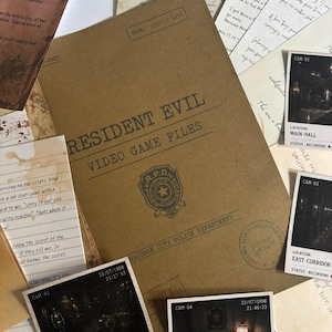 Pode incluir: Uma pasta bege Resident Evil Video Game Files do Departamento de Polícia de Raccoon City, rodeada por várias cartas manuscritas, notas e várias fotografias de câmaras de segurança a preto e branco com locais e carimbos de data.