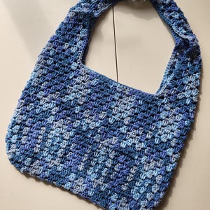 Pu&ograve; includere: Borsa a tracolla all'uncinetto blu fatta a mano. La borsa presenta un motivo a punto strutturato e un'ampia tracolla. &Egrave; di medie dimensioni, ideale per l'uso quotidiano.
