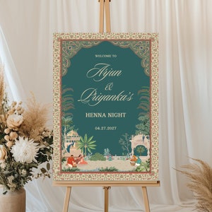 May include: A teal blue welcome sign with a gold ornate frame and a floral design. The sign reads "Welcome to Arjun & Priyanka's Henna Night 04.27.2027".