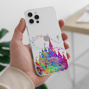 May include: A clear phone case with a watercolor design of a castle and a fairy flying above it. The castle is in shades of pink, blue, green, and yellow. The fairy is in shades of blue and green. The case is for an iPhone 13 Pro Max.