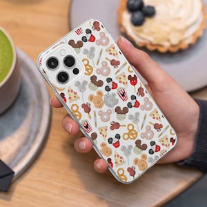 Könnte beinhalten: Eine transparente Handyhülle mit weißem Hintergrund und einem sich wiederholenden Muster aus Mickey-Maus-Ohren, Brezeln, Pizzastücken, Popcorn-Eimern und Lutschern.