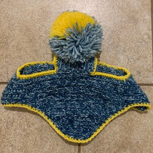 May include: Blue and yellow crocheted dog hat with a pom pom on top.