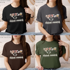 May include: Four t-shirts in different colors with a floral design and the text "clinical research". The colors are black, charcoal, brown, and green.