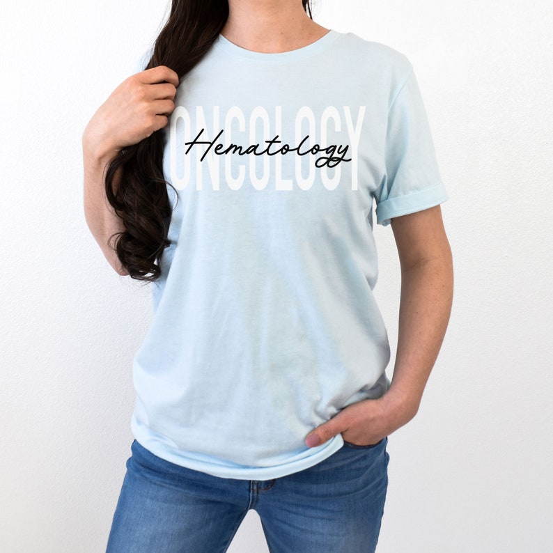 May include: A light blue t-shirt with the text "Hematology" in white letters and "ONCOLOGY" in white block letters.