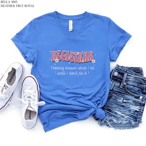 May include: A royal blue v-neck t-shirt with the text "REGISTRAR" in pink with white flowers and sparkles. The text below reads "Nobody knows what I do *until I don't do it*"