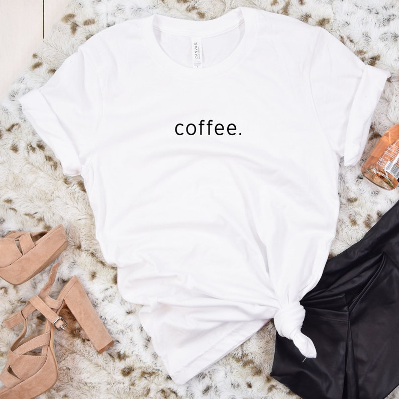 Puede incluir: Camiseta blanca con la palabra "coffee." impresa en negro en la parte delantera.