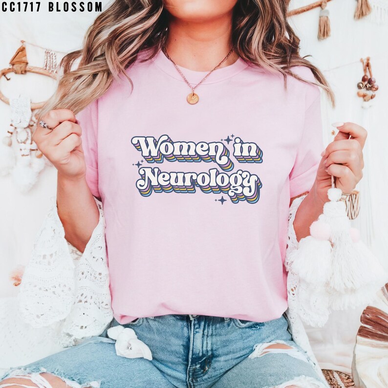 May include: A pink t-shirt with the text "Women in Neurology" in a retro rainbow font with stars.
