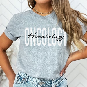 May include: Gray t-shirt with the text "ONCOLOGY" in white letters and "Hematology" written in black cursive script.