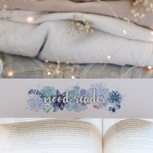 Könnte beinhalten: Weißes Lesezeichen mit einem Aquarell-Design aus blauen und grünen Sukkulenten. Das Lesezeichen trägt den Text "mood reader" in weißen Buchstaben.