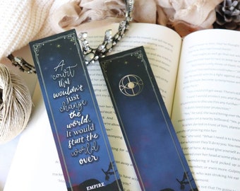May include: Two bookmarks with a dark blue background and a quote from the book "Empire of Storms" by S.J.M. The quote reads "A court that wouldn't just change the world. It would start the world over."
