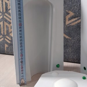 May include: White plaster mold for making a bottle shaped candle. The mold is 30 inches tall and has a round base. The mold is made in two pieces, with a top and bottom section. The mold is designed to create a bottle shaped candle with a smooth, even surface.