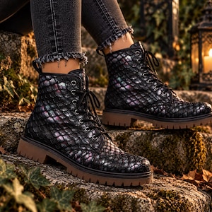 May include: A pair of black lace-up ankle boots featuring a textured, iridescent scale pattern that shifts between dark tones and subtle purple and blue highlights. The boots have black laces, silver-toned eyelets, and a thick, flat brown rubber sole.