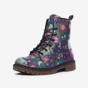 Op de afbeelding: Paarse, blauwe en gouden combat boots met zwarte veters. Het patroon bevat sterren, manen, vlinders en bloemen.