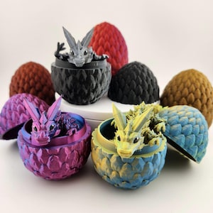 May include: Four dragon egg-shaped containers with small dragons inside. The eggs are in different colours: black, brown, blue, and purple. The dragons are in different colours: grey, yellow, pink, and white.