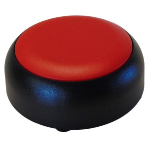 Może przedstawiać: Czerwony przycisk z czarną podstawą. Przycisk jest okrągły i ma gładką powierzchnię. Podstawa jest fakturowana i ma niewielki rant wokół krawędzi.