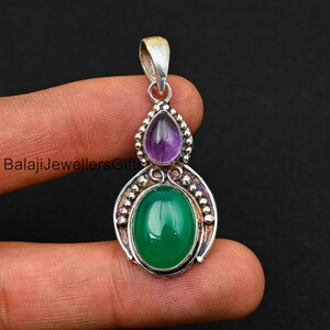 May include: Silver pendant with a green onyx and a purple amethyst gemstone. The pendant has an ornate design with silver beads.