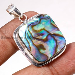 May include: A square pendant featuring an abalone shell centre, set in silver. The shell's iridescent surface shows blues, greens, and browns. The pendant has a silver bail for a chain. The text "BalajiJewellersGifts" is visible.