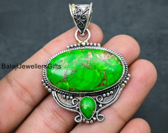 May include: A silver pendant with a green turquoise stone set in an oval shape. The pendant has intricate silver detailing and a bail for attaching a chain.