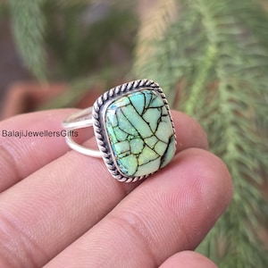 Puede incluir: Anillo de plata con una piedra cuadrada de color verde claro. La piedra tiene un patrón agrietado con líneas negras y un borde en forma de cuerda. El anillo está en un dedo, con el texto "BalajiJewellersGifts" visible.