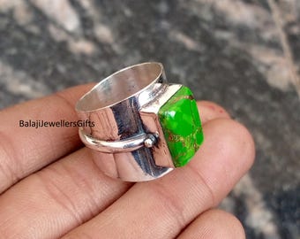 Könnte beinhalten: Ein silberner Ring mit einem großen, rechteckigen, leuchtend grünen Stein. Der Ring hat ein breites Band und ein dekoratives Element an der Seite. Der Text "BalajiJewellersGifts" ist auf der Seite des Rings zu sehen.