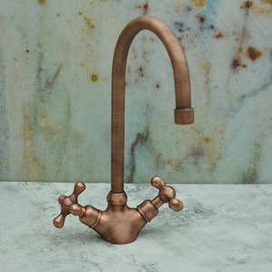 Könnte beinhalten: Ein Küchenwasserhahn aus Kupfer mit einem hohen Auslauf und zwei kreuzförmigen Griffen.