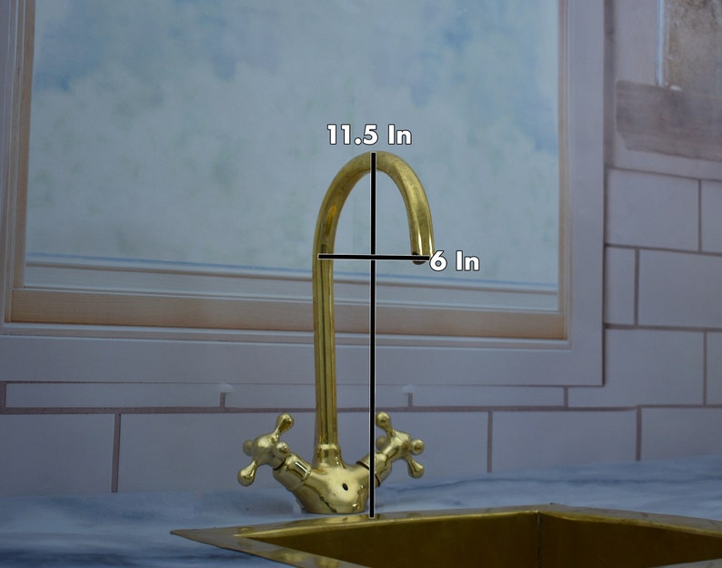May include: A gold-toned kitchen faucet with two handles and a curved spout. The faucet is 11.5 inches tall and 6 inches wide.