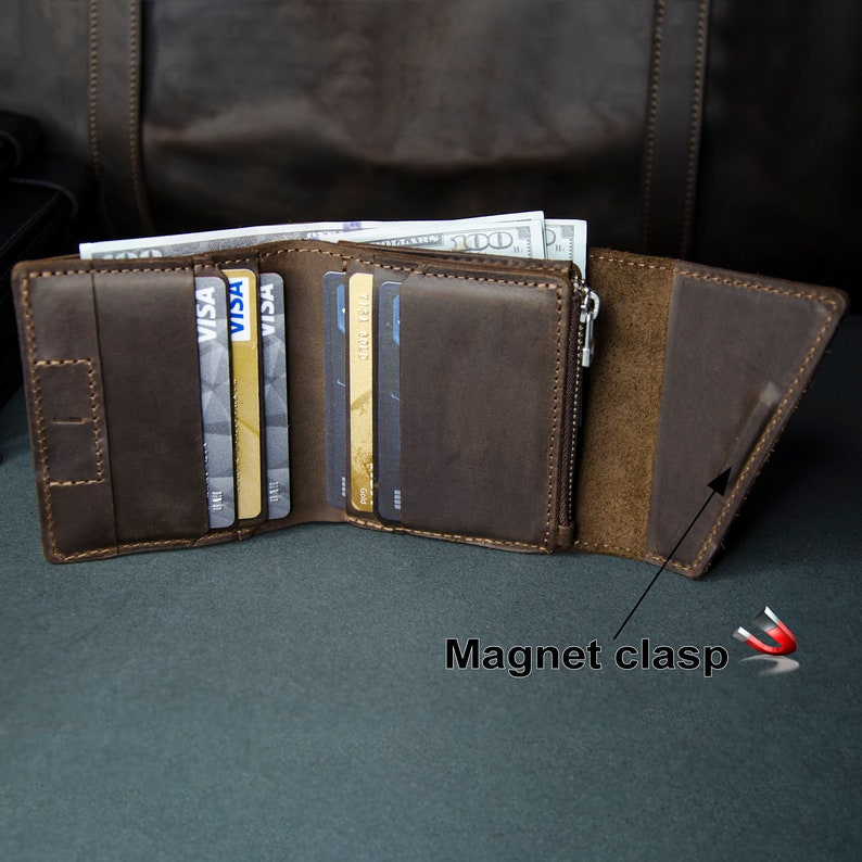 May include: A brown leather wallet with a zippered pocket and a magnetic clasp. The wallet is open and has several credit cards and cash inside.