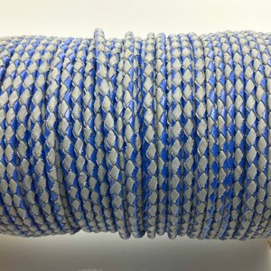 May include: A spool of braided leather cord in a blue and gray diamond pattern.