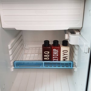 May include: Three condiment bottles in a white refrigerator. The bottles are labeled "BBQ", "Ketchup", and "Mayo".