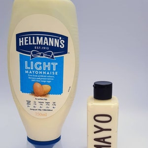 May include: Two bottles of mayonnaise, one large and one small. The large bottle is labeled "Hellmann's Light Mayonnaise" and is 750 ml. The small bottle is labeled "MAYO".