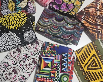 May include: A collection of colorful fabric pieces with various patterns. Designs include floral, geometric, and abstract motifs in shades of red, yellow, blue, and green. The fabrics are folded and stacked, showcasing the diverse textures and prints.