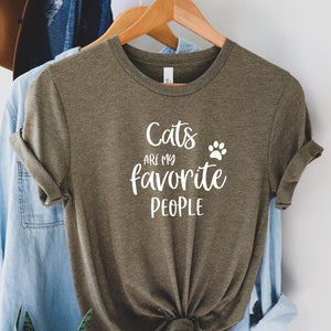 May include: A green t-shirt with the text "Cats are my favorite people" and a paw print in white.