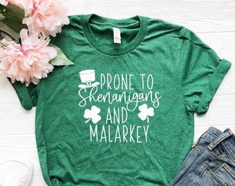 May include: Green t-shirt with white text that reads "Prone to Shenanigans and Malarkey". The text is surrounded by shamrock designs.