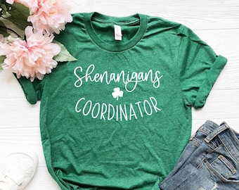 May include: Green t-shirt with white text that reads "Shenanigans Coordinator" and a shamrock graphic.