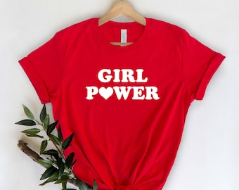 May include: Red t-shirt with white text that says "GIRL POWER" with a heart in place of the "O".