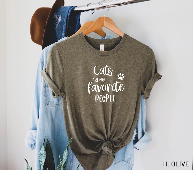 May include: A green t-shirt with the text "Cats are my favorite people" and a paw print in white.