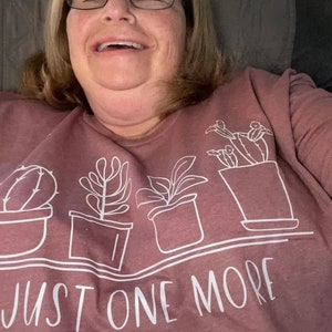 Show off your plant passion with our "Just One More" Cactus and Succulent Graphic T-Shirt! Designed for those who can never have too many plants, this tee is a fun nod to the joy of gardening.