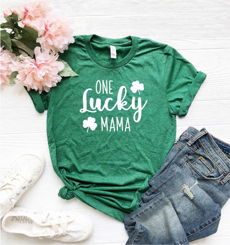May include: Green t-shirt with white text that reads "One Lucky Mama" and a shamrock graphic.
