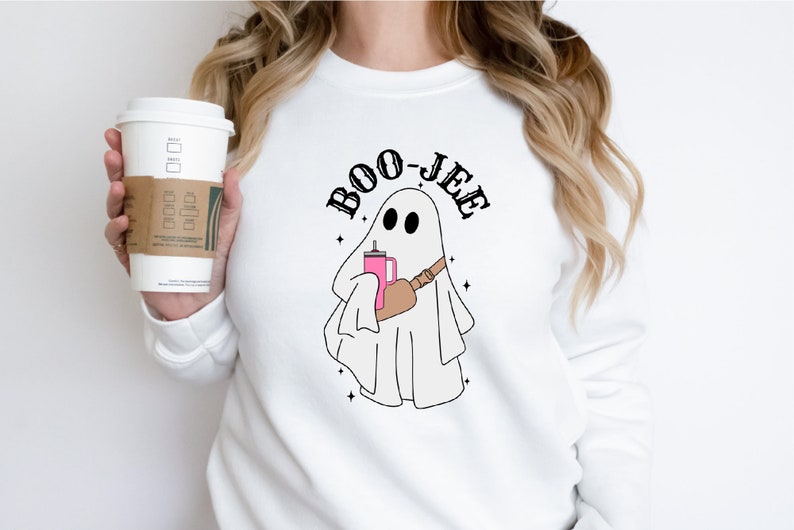 May include: White sweatshirt with a ghost holding a pink drink and the text "BOO-JEE" printed on it.